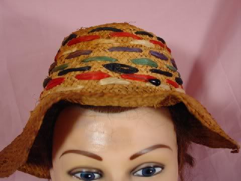 The top of hat is intertwined with different color wicker type strings